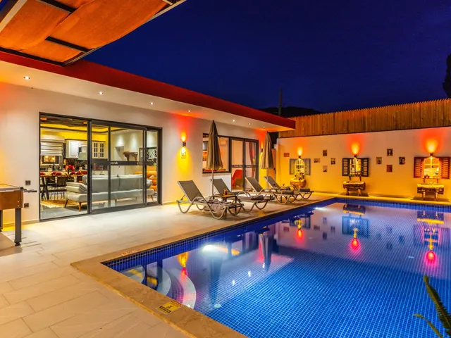 Luxury villa at night with a beautifully lit pool and warm glowing interior