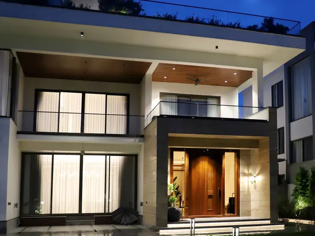 Modern luxury house exterior lit up at night with a warm glowing entry