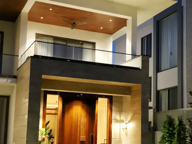 Illuminated entrance of a modern luxury home at night with lit steps and walls