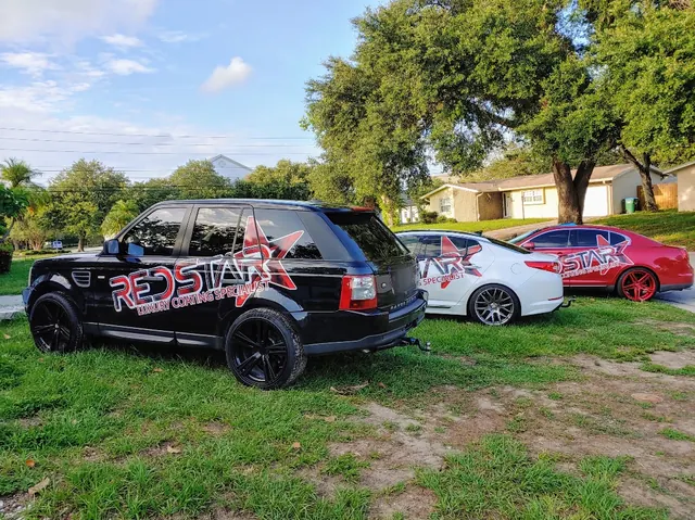 Black Red Star Range Rover parked on grass beside a white and a red car in matching Red Star wraps